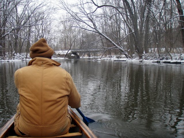 Jim paddling a canoe in winter
